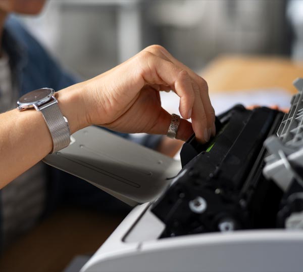 Assistenza informatica aziendale Gallarate: lavoratore che ripara stampante